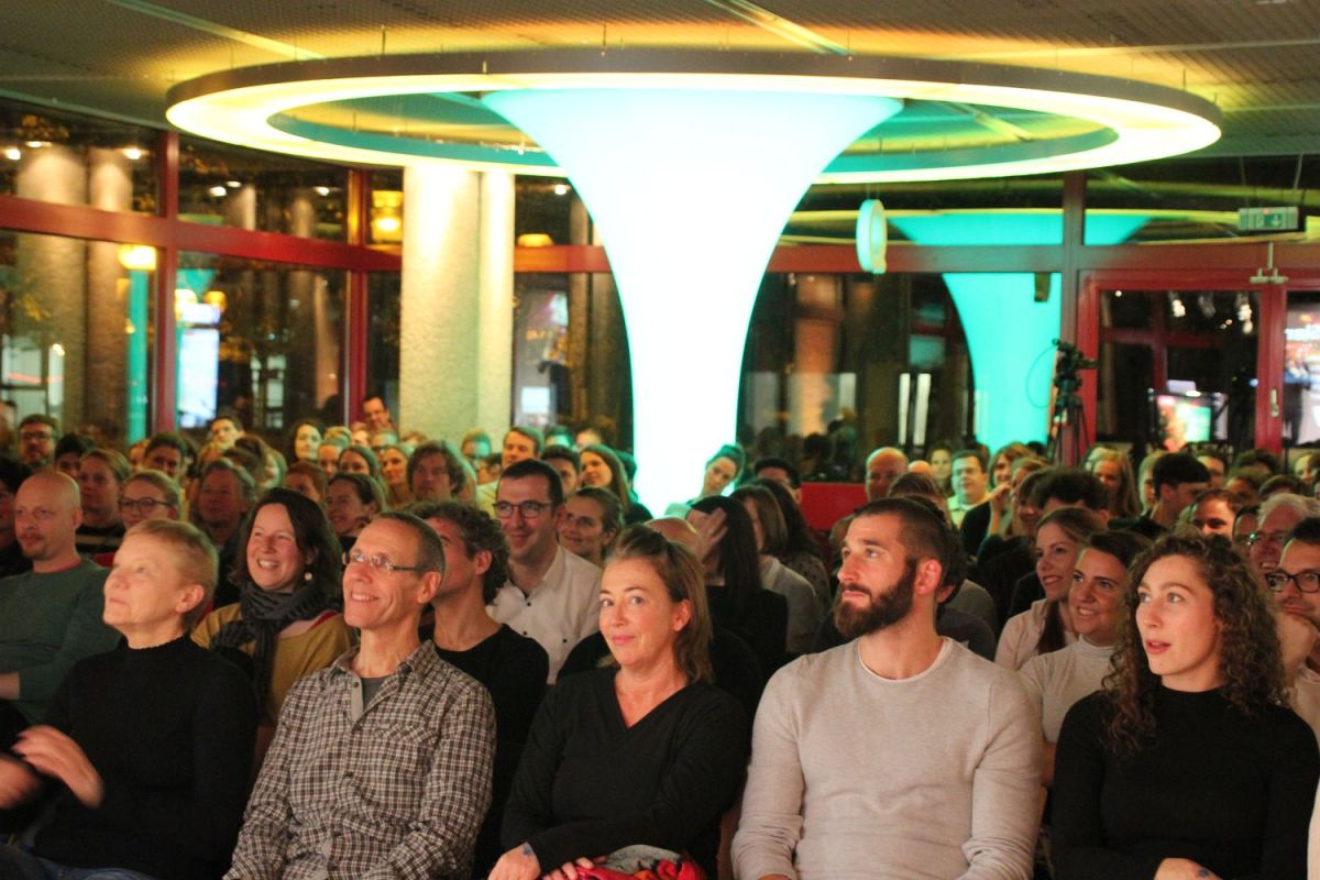 Publikum dicht an dicht auf Stühlen im Veranstaltungsraum der Zentralbibliothek.