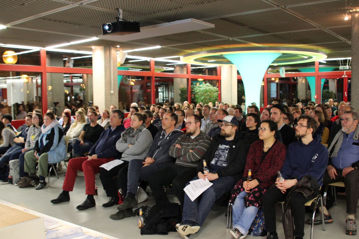 Publikum dicht an dicht auf Stühlen im Veranstaltungsraum der Zentralbibliothek.